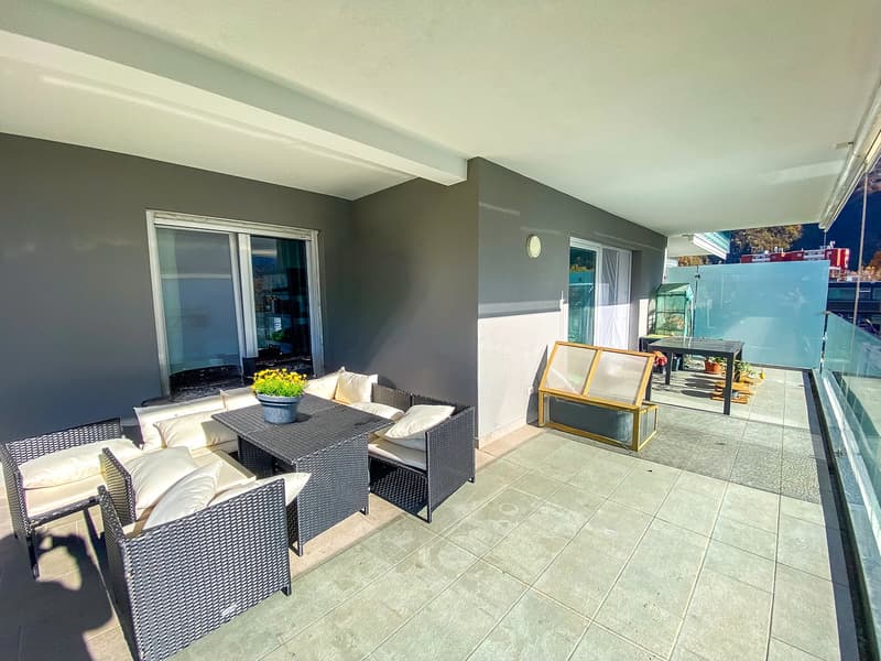 tiled floor, cushioned seating, table, potted plant, view of trees