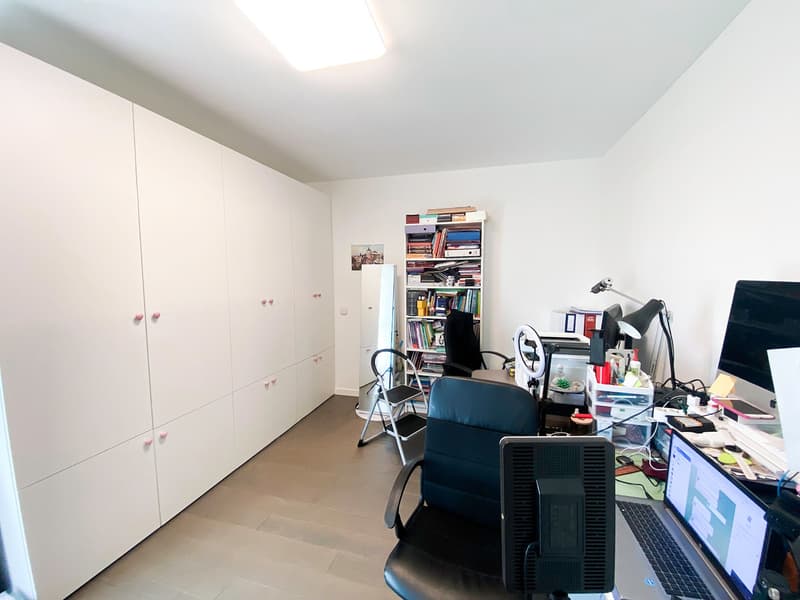 empty room, white wall, wooden floor, white cabinets, bookshelves, desk, computer, laptop, office chairs