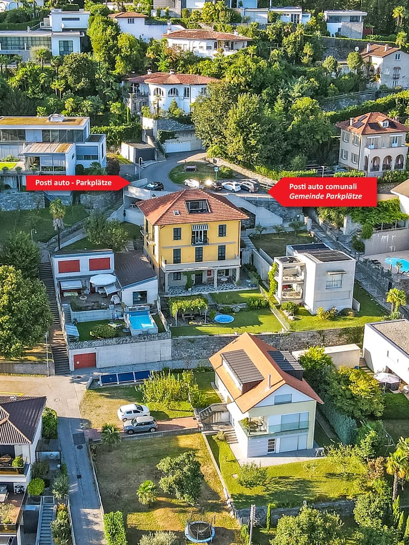 Cluster of houses with private parking, communal parking, swimming pool visible, hilly area