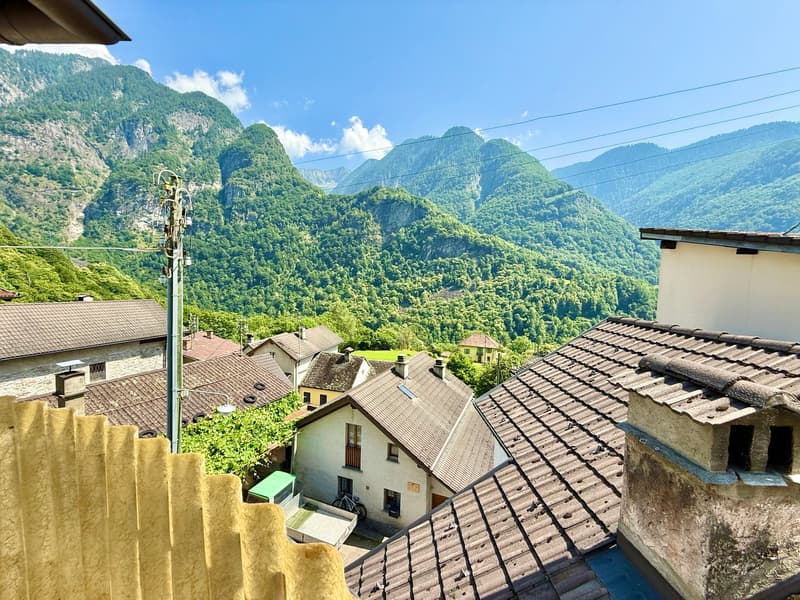 small town, mountain view, brown roofs, white walls, solar panel on one of the roofs