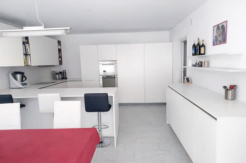 modern design, stainless steel oven, white marble countertop, white cabinets, bar stools, kitchen island, red table