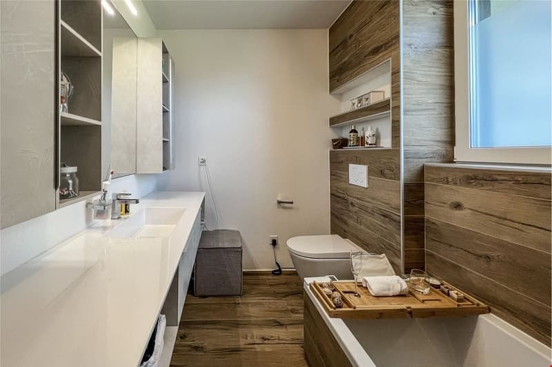 double sink, modern vanity, toilet, shower, wooden floors, white walls, shelving, modern fixtures