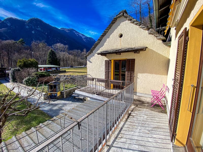 Stone house, metal railing, wooden door, balcony, mountain view