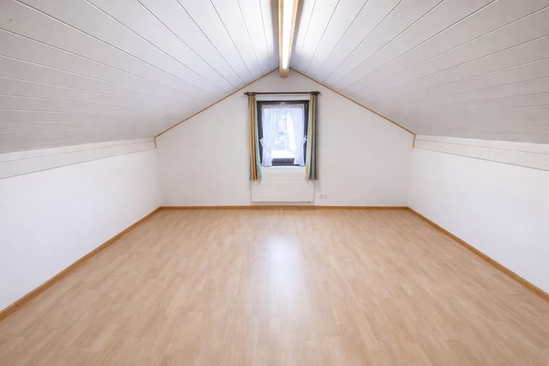 empty room with white walls, wooden floor, window with white curtains, and ceiling lamp