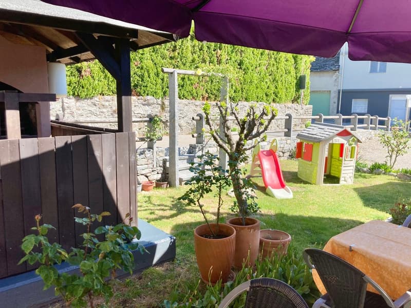 garden with slide, patio, chair, table, wooden fence, purple umbrella, potted plants