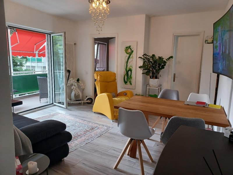 living room with balcony, wooden floor, yellow chair, dining table, TV, radiator, chandelier, potted plant