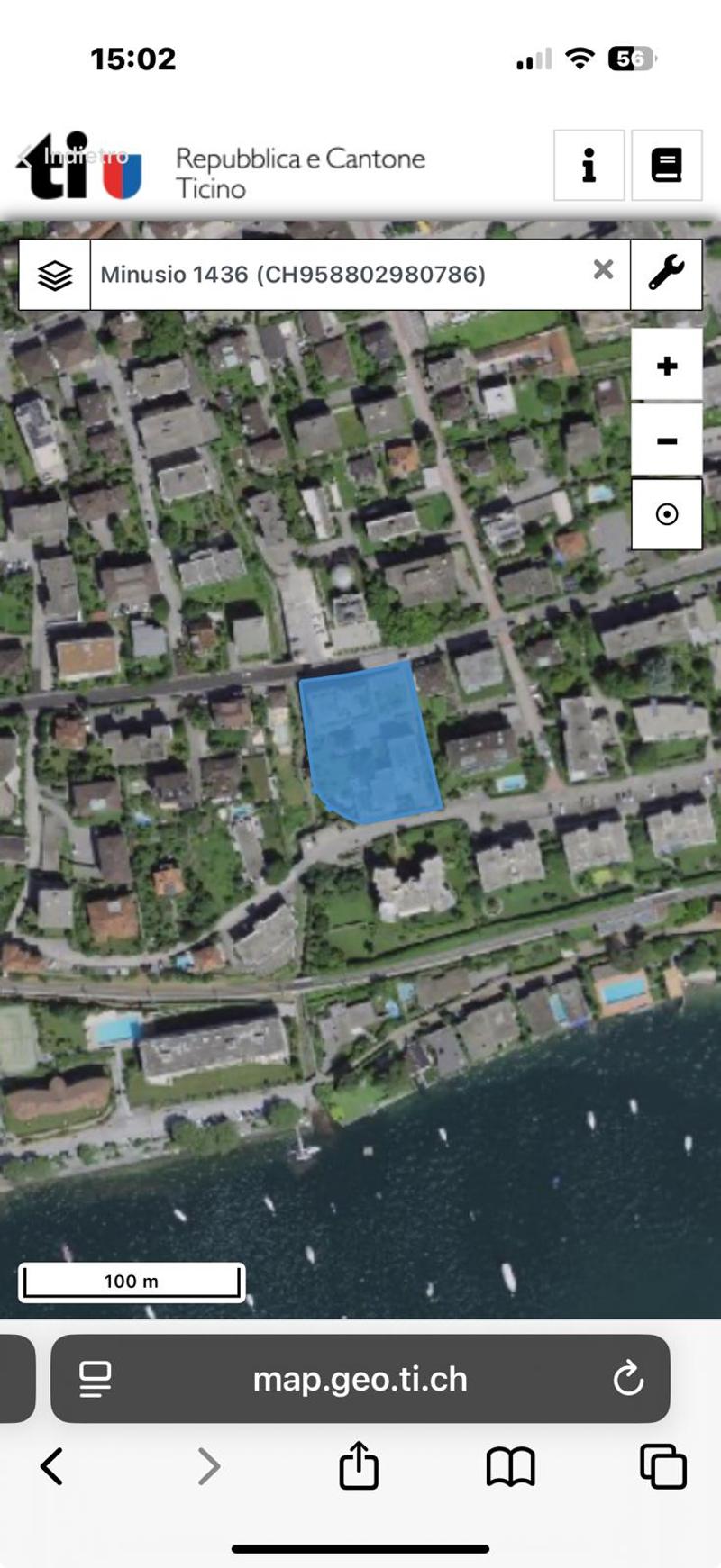 Aerial view of a residential area with a highlighted property, swimming pool, and surrounding buildings