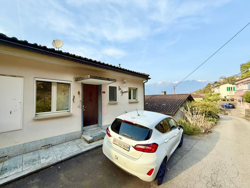 Single-family house, beige exterior, brown door, white windows, satellite dish, car parked in front
