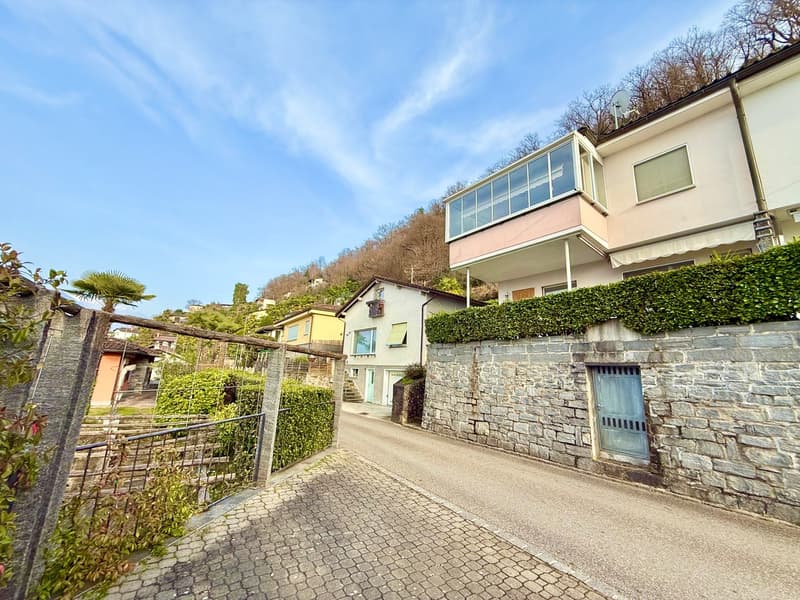 Houses on a hill, stone wall, brick road, hedges, clear sky