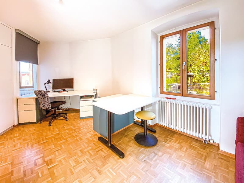 Office room with two desks, chairs, computer, lamp, radiator, parquet floor, windows