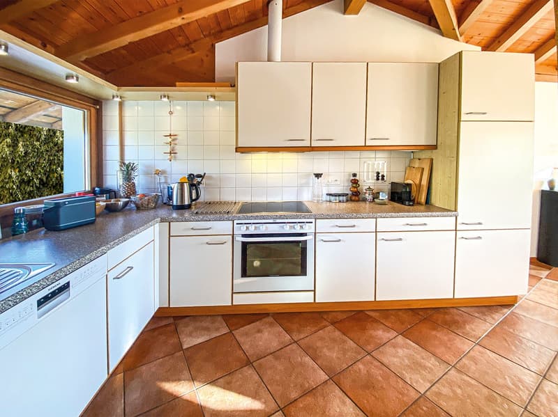 modern kitchen with white cabinets, granite countertops, stainless steel appliances, tiled floor, large window