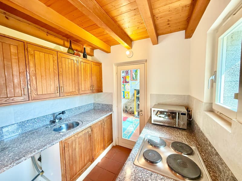 kitchen with wooden cabinets, granite countertop, sink, faucet, microwave, stove, wooden ceiling