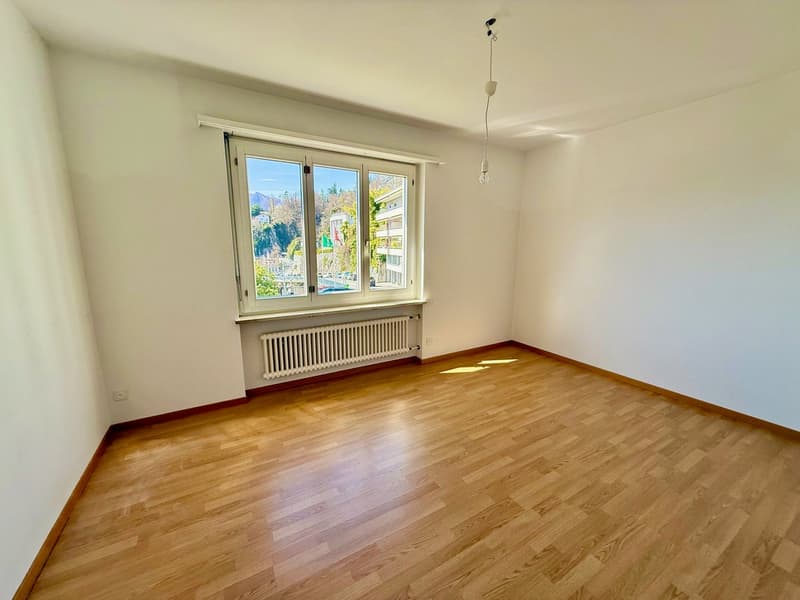 empty room, white walls, wooden floor, large window, white radiator