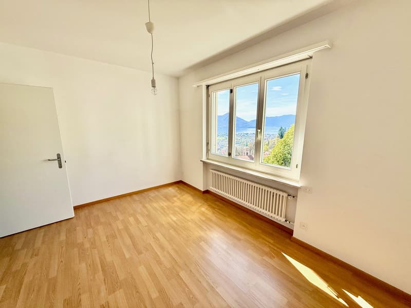 empty room, wooden floor, white walls, large window, white radiator