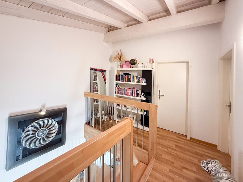 wooden floor, white walls, wooden railing, white door, bookshelf, mirror, picture frame