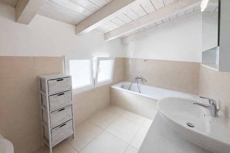 Bathroom with bathtub, sink, toilet, wooden ceiling, tiled floor, storage unit