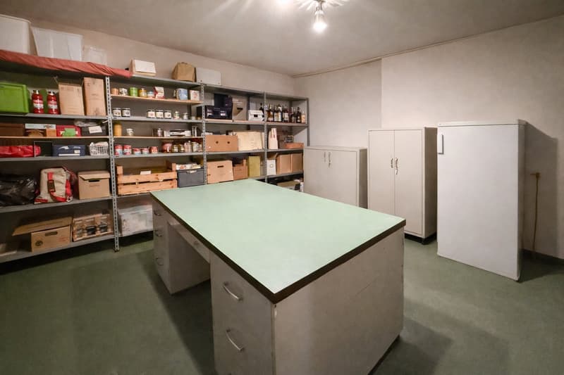 Storage room with shelves, desk, cabinets, and various items