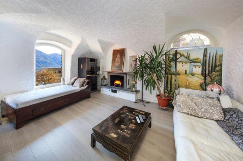 fireplace, wooden bed, couch, coffee table, potted plant, picture frame, lamps, view of mountains