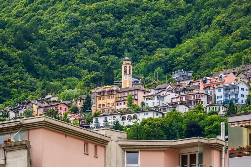 Mountain town, several multi-story buildings, one with a clock tower, lots of greenery
