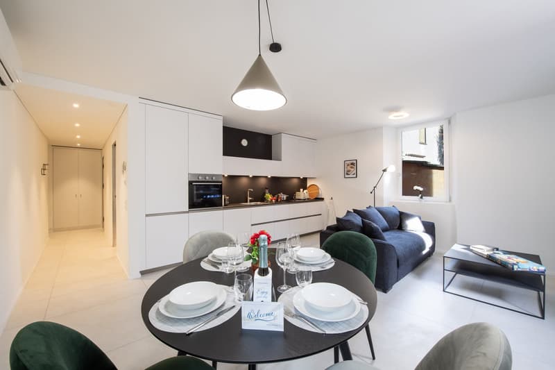 open-plan living area, kitchen with oven and sink, modern dining area, modern sofa, coffee table, artwork on wall