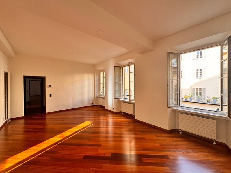 empty room, wooden floor, white walls, large windows, radiators, door