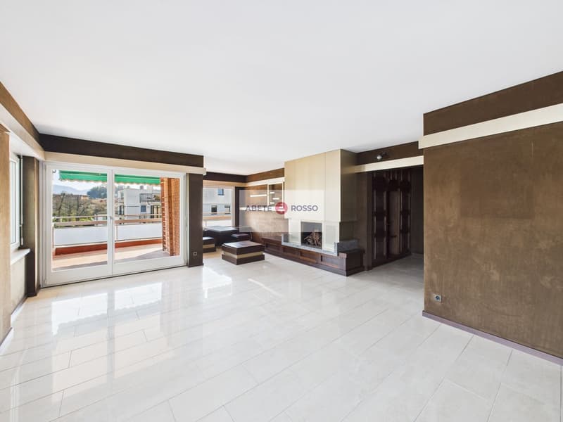 Spacious living room with large windows, hardwood floors, and a fireplace. The room has a modern and minimalist design with neutral colors and clean lines.