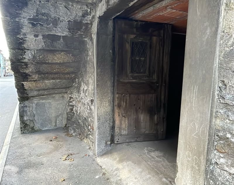 stone facade, wooden door, visible basement entrance, pavement