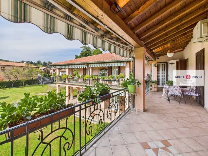 large balcony with wooden ceiling, awning, decorative railing, plants, garden view