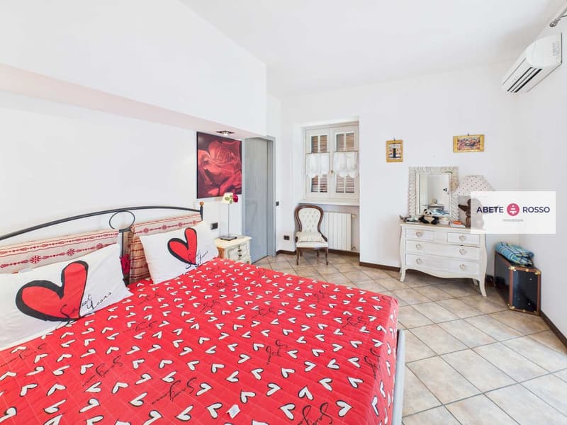 Red heart theme bed, two white nightstands, white radiator, decorative items, picture frames on wall, mirror on dresser