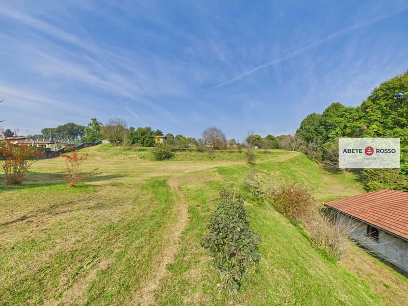 hilly landscape, grassy terrain, trees, pathway, building on right