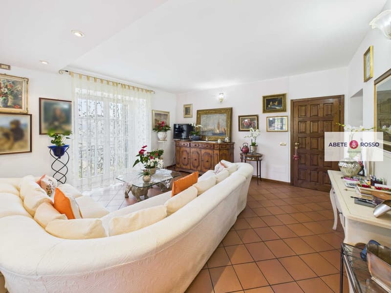 white couch, tiled floor, wooden cabinet, flower vases, television, framed pictures, window with curtains