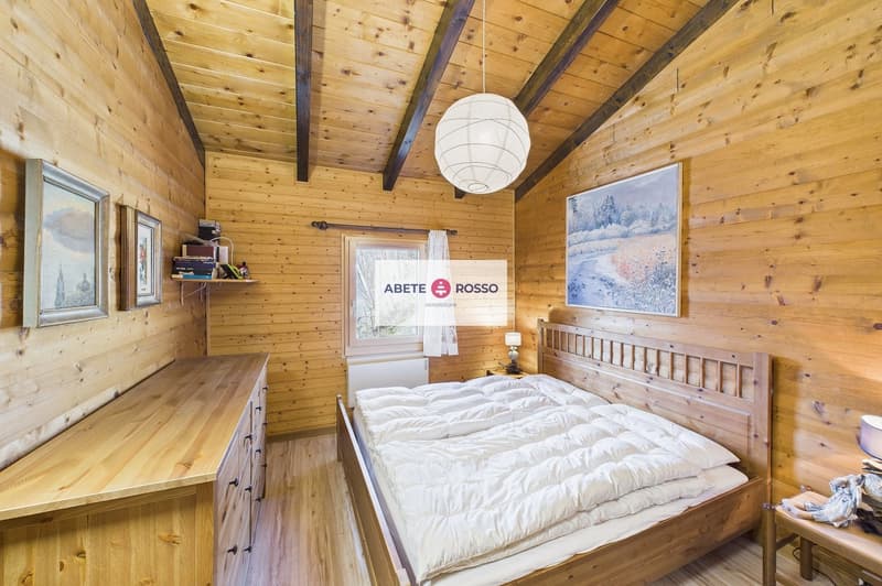 wooden walls, bed, wooden cabinet, nightstand, lamp, picture frames, window with curtains