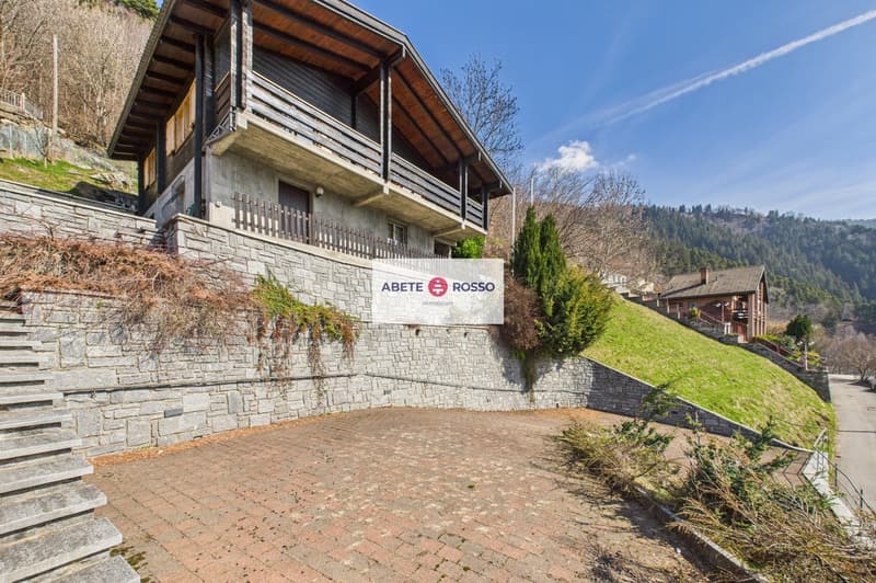 House on a slope, wooden balcony, brick wall, driveway, mountain view