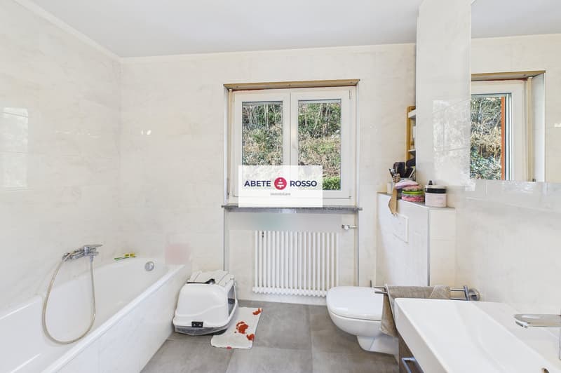 modern bathroom with bathtub, toilet, sink, radiator, windows