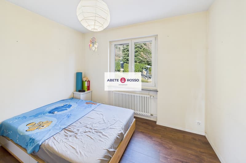 single bed, wooden floor, white walls, window, radiator, nightstand, lamp, decorative items