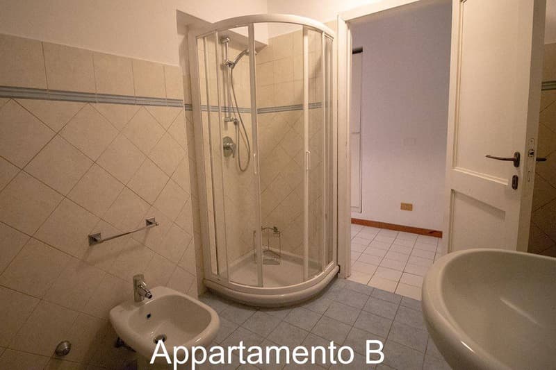 Bathroom with shower, sink, bidet, and white tiles