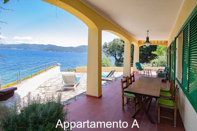 Wooden table with 4 chairs, chairs and sofa on the balcony, view of the sea