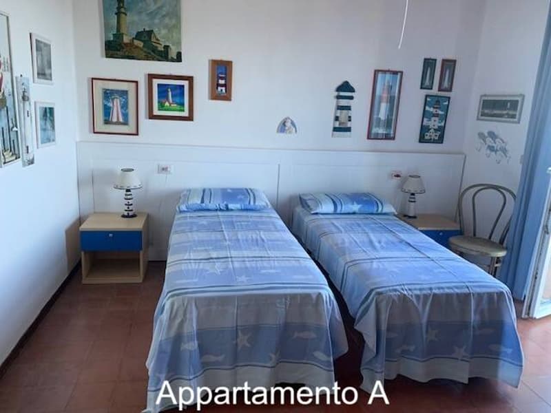bedroom with two twin beds, nightstands with lamps, wall decor, sliding door