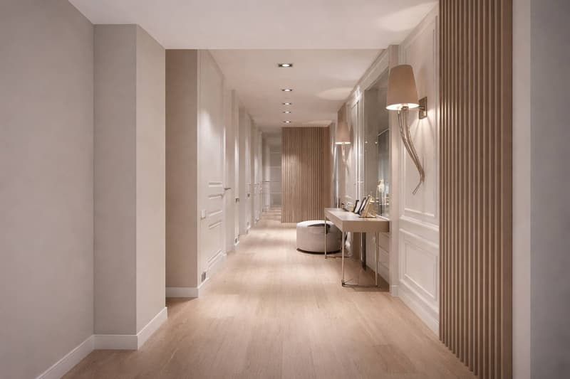 long hallway, wooden floor, white walls, wall lamps, white desk, mirror, white ottoman