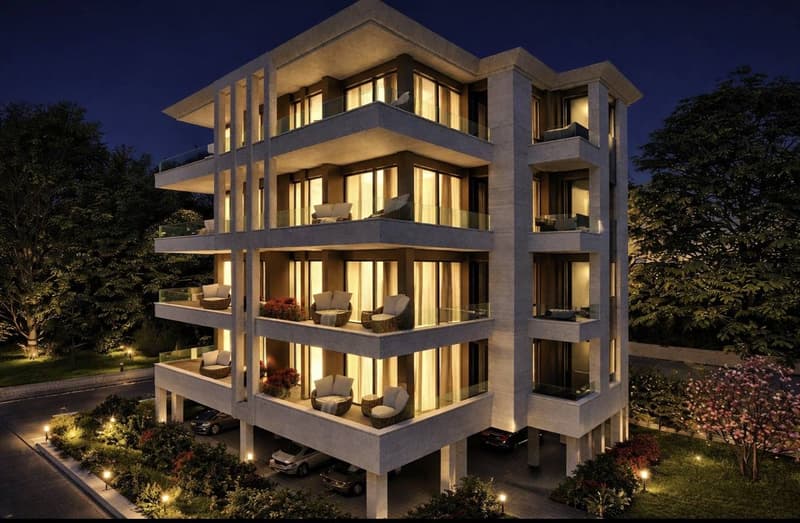 Modern multi-story building with multiple balconies, large windows, and outdoor seating areas.
