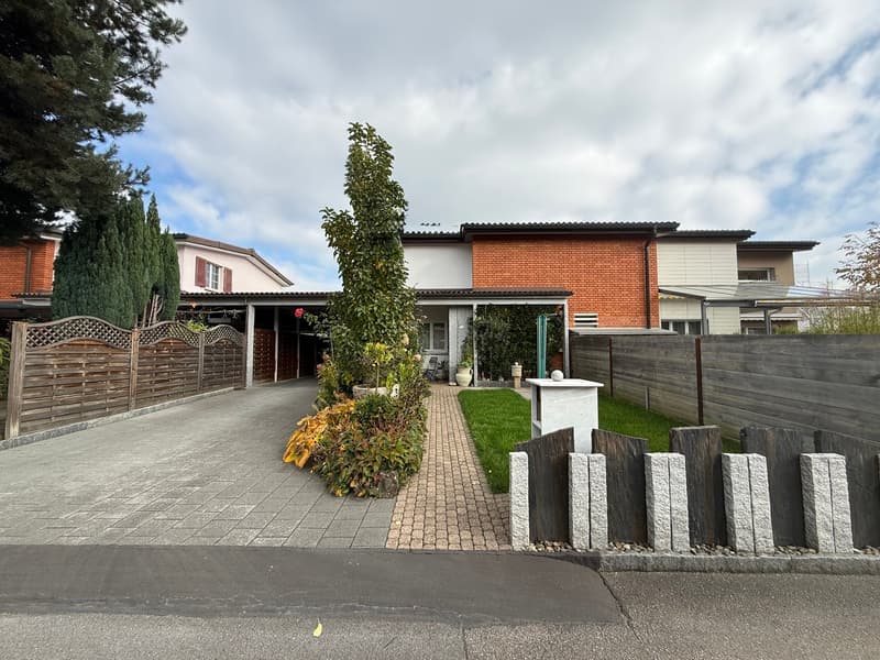 Modern house, red brick, white walls, carport, driveway, brick pathway, wooden fence, lawn, shrubs, greenery, trees
