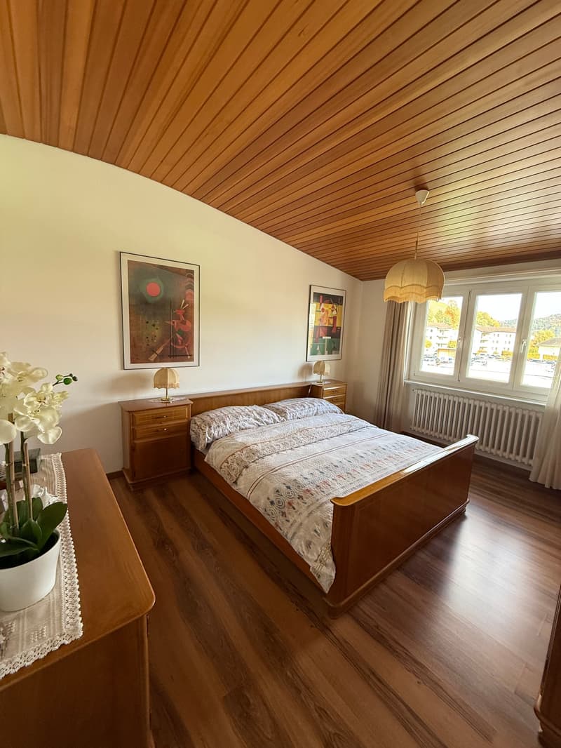 double bed, wooden cabinet, lamps, wooden floor, wooden ceiling, artwork, flower vase, window, curtains
