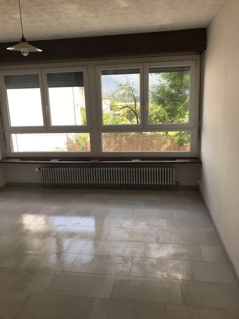 empty room, large window, white ceiling and walls, radiator, wooden window sill, tiled floor