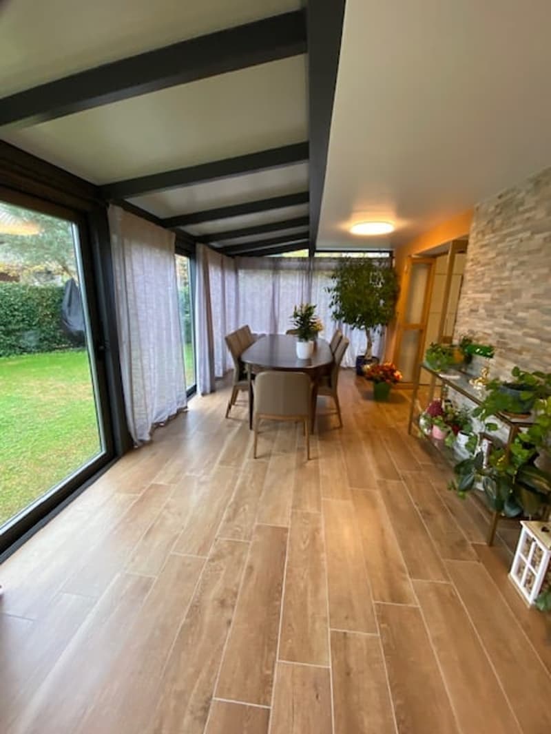 wooden floor, large windows, outdoor dining area with table and chairs, plants, glass sliding doors, tiled ceiling