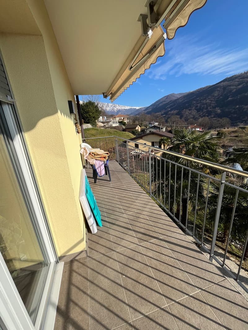 Balcony with tile flooring, metal railing, chairs, and plants, with beautiful mountain view