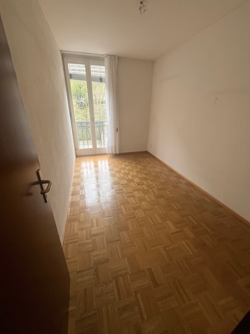 Hardwood floor, sliding glass doors leading to balcony, white walls