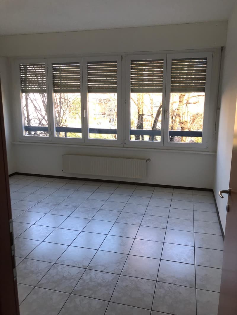 tiled floor, white walls, large windows, balcony with railings, view of trees
