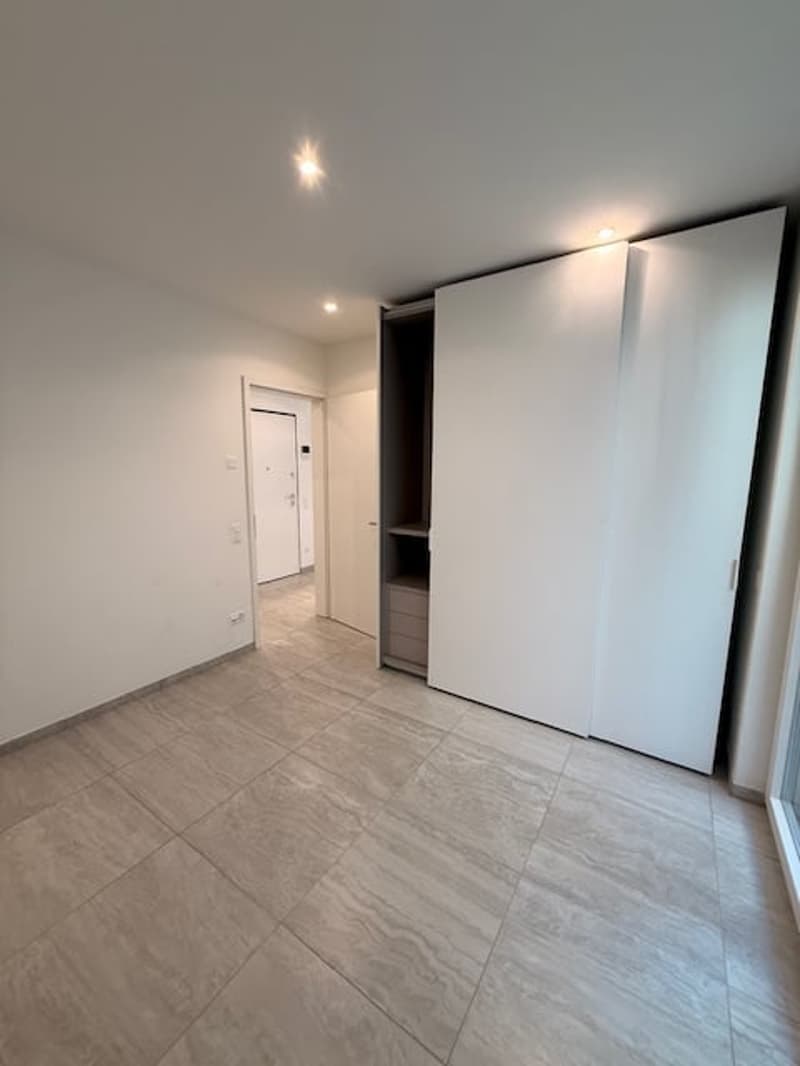 white sliding doors, tiled flooring, white walls, recessed lighting, closet, interior door
