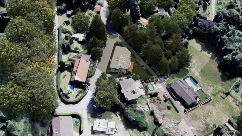 Aerial view of a housing complex with multiple houses, swimming pools, and a driveway with a road.