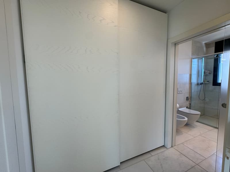 white walls, sliding closet, toilet, bidet, shower glass door, power outlet